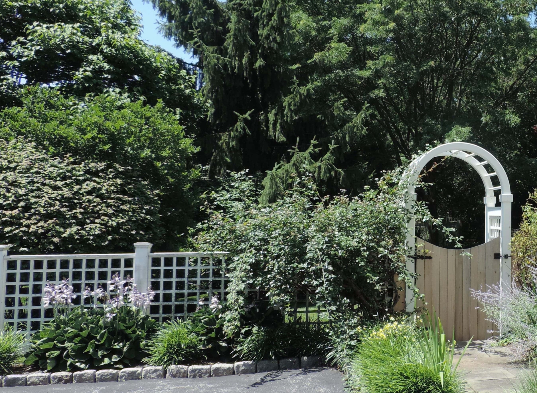 white vinyl garden arbor with wood gate