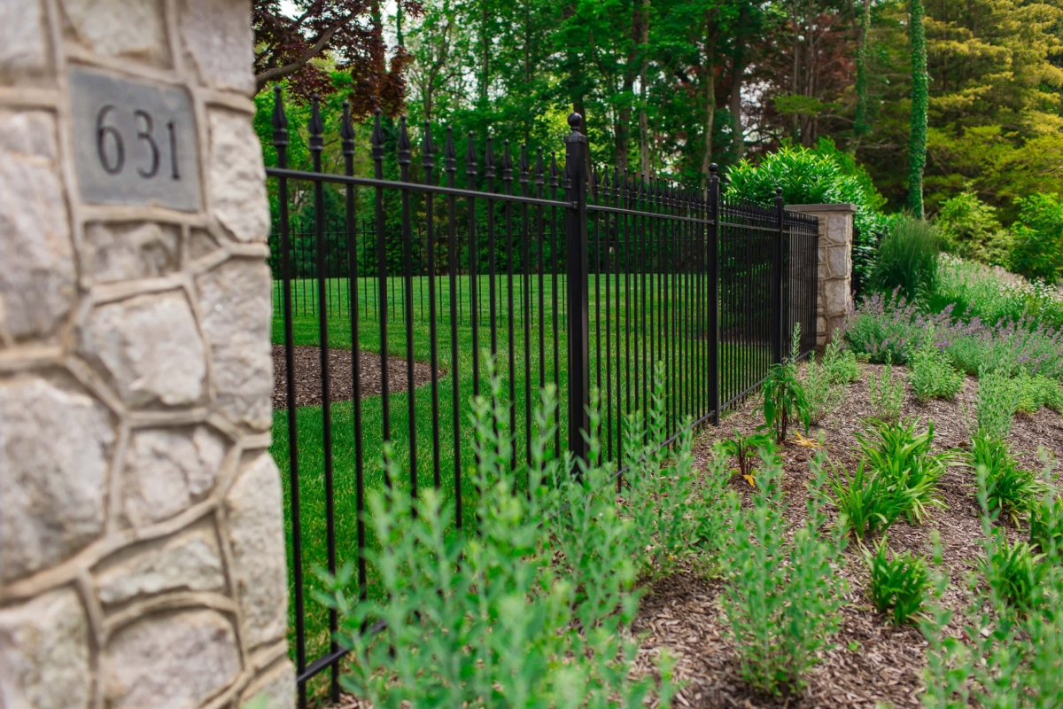 black steel fence connected to stone pillars