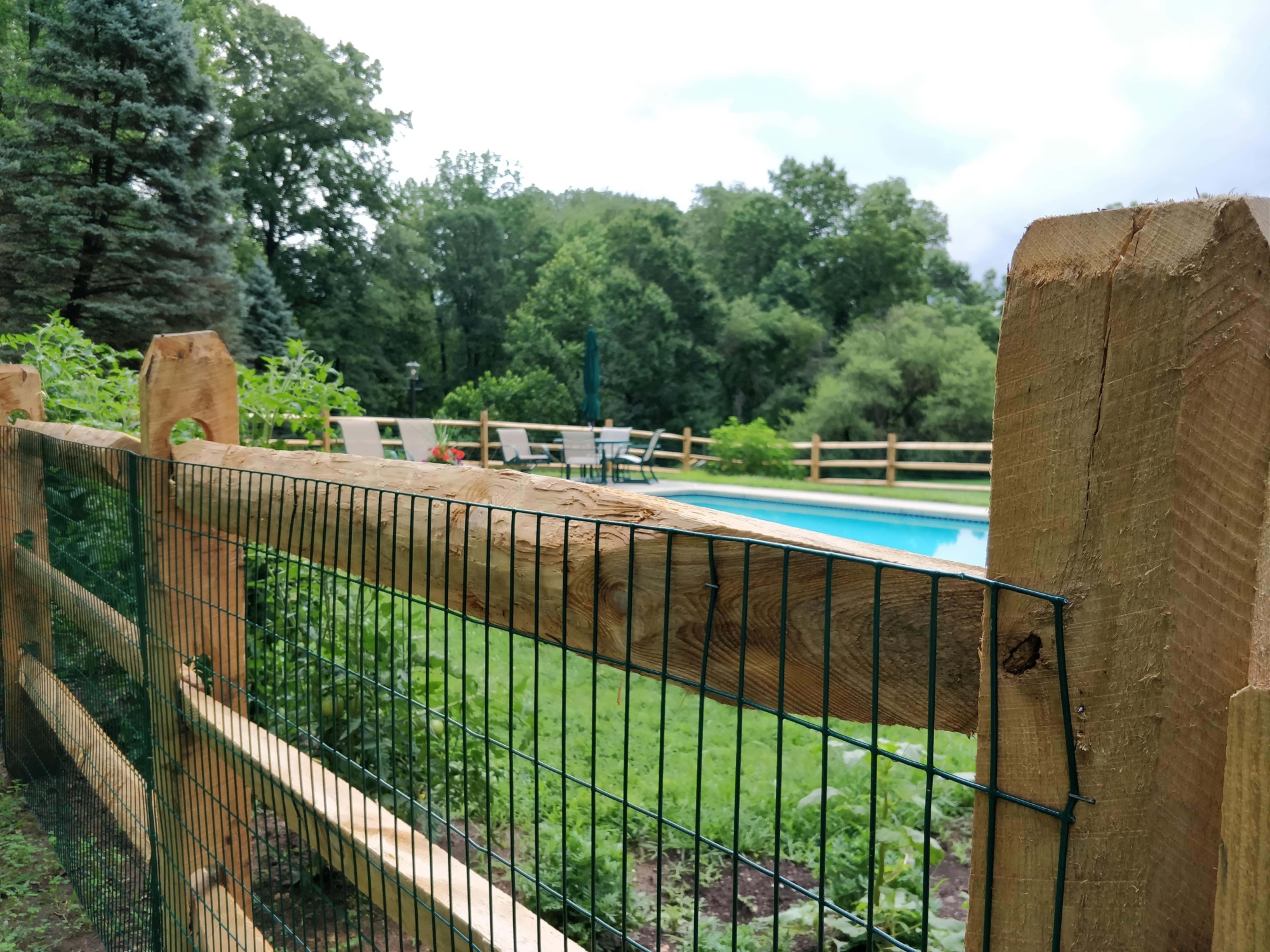 wood split rail and wire fence around swimming pool