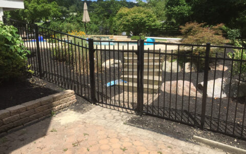 black ornamental fence around pool with gate