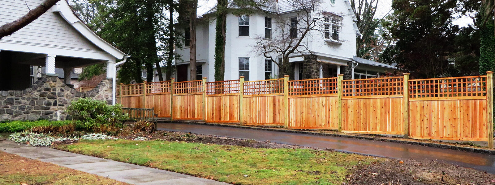 Framed wood privacy fencing with lattice beside drive