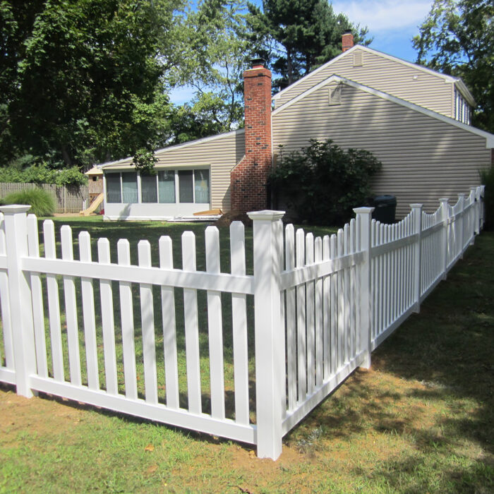 white vinyl concaved picket fence with post caps in yard