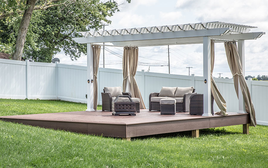 Stand-alone deck with pergola in middle of backyard lawn