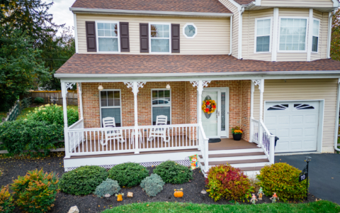 image of a porch with decorative details and lattice skirting in media pa built by integrous fences and decks featuring timbertech decking white vinyl railing and white vinyl with decorative spindles decorative white posts white decorative post to beam brackets and underdeck lattice skirting