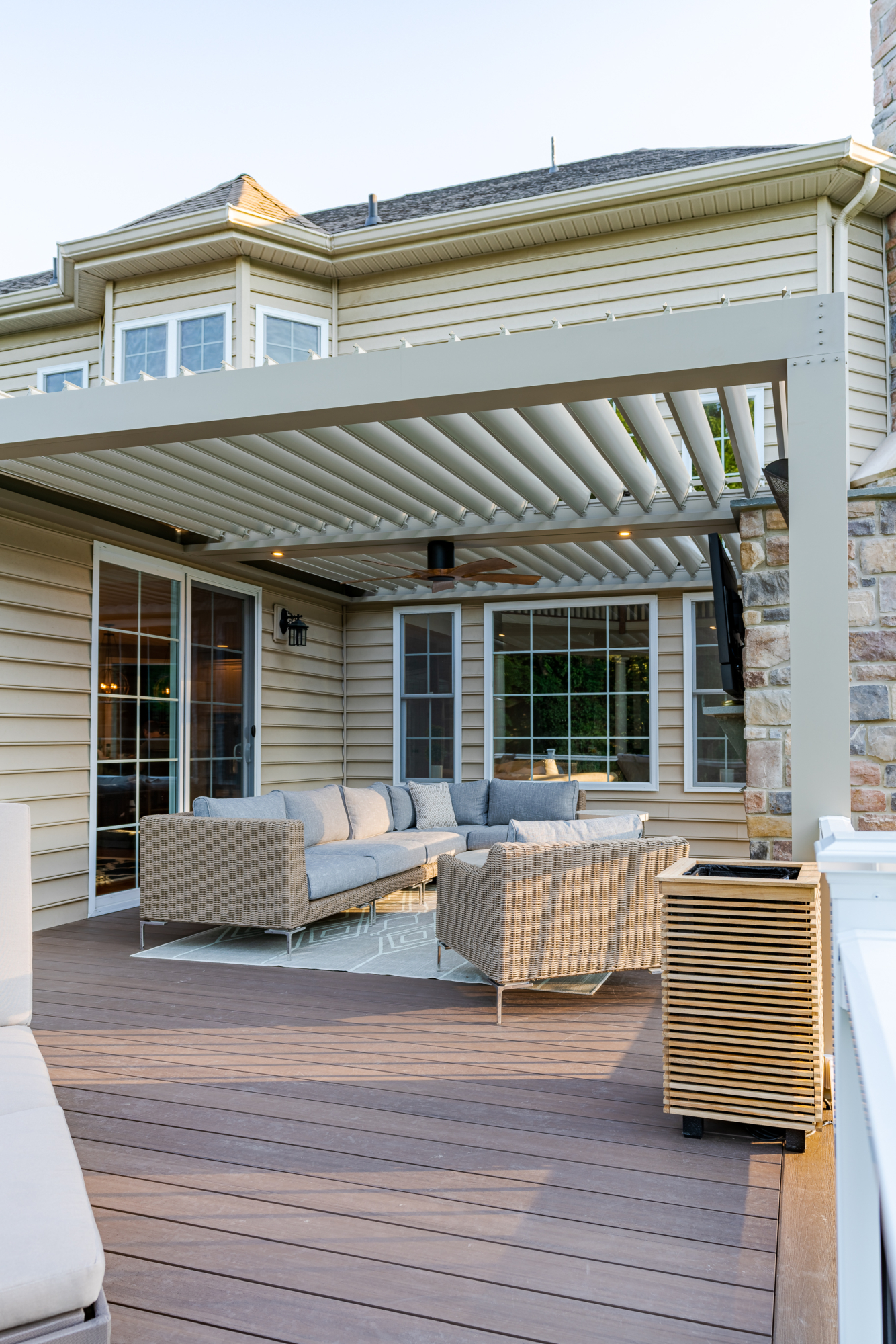 image of a timbertech deck with an equniox louvered roof creating the perfect oudoor living space designed and built by integrous fences and decks