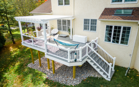 image of a deck with pergola in newtown square pa built by integrous fences and decks featuring a white vinyl pergola sea salt timbertech decking white vinyl railing with black aluminum railing