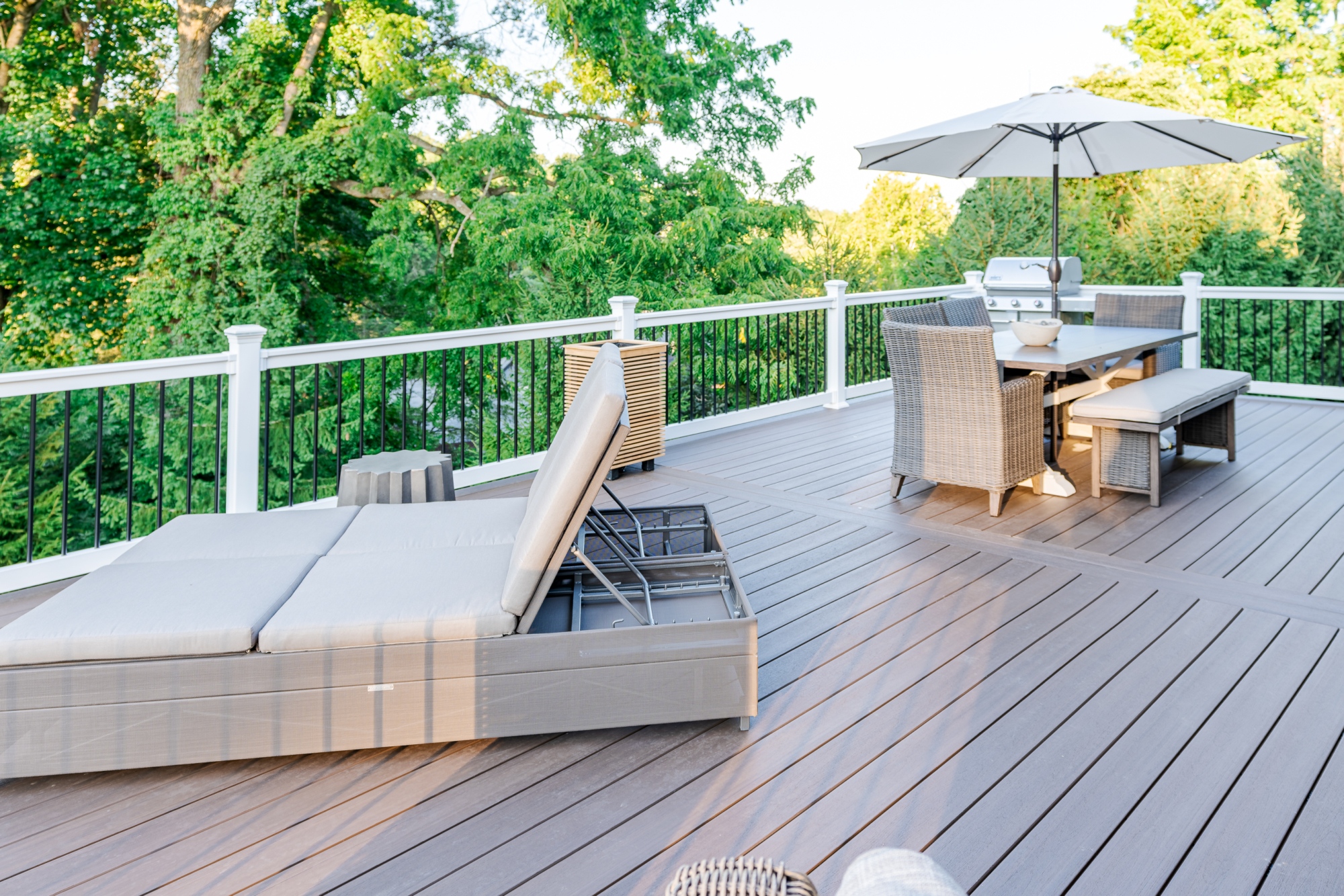 image of a timbertech deck with white vynl railing and black aluminum balusters built by integrous fences and decks