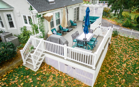 image of a deck in paoli pa built by integrous fences and decks featuring timbertech decking lattice skirting and privacy wall and white vinyl railing