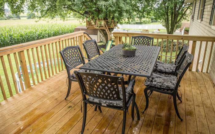Outdoor dining set on stained wood deck